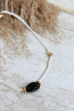 White beaded necklace with black stone